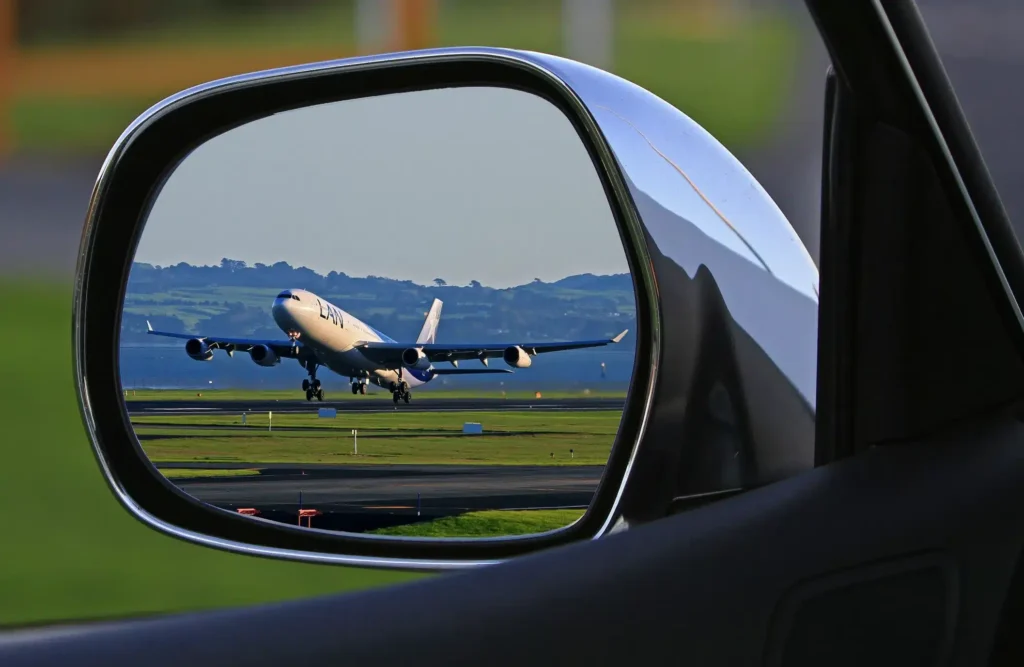 plane taking off in wing mirror
