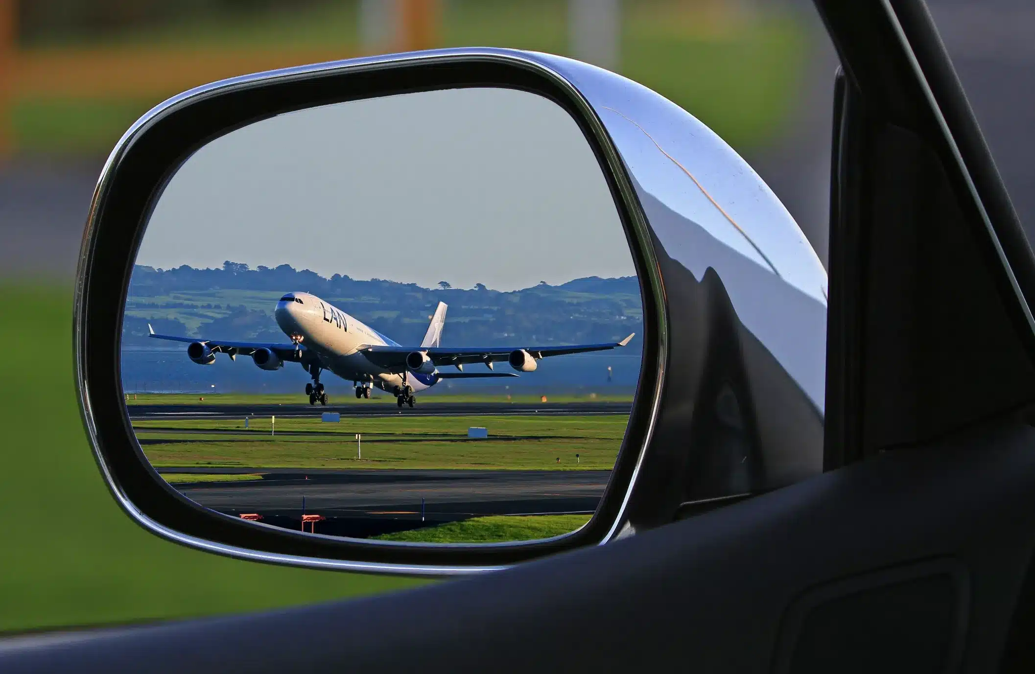 plane taking off in wing mirror